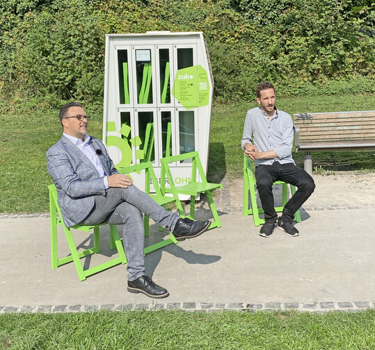 Iserlohns Bürgermeister Michael Joithe weiht mit Erik Czejka die neuen Stühle am Fritz-Kühn-Platz ein.