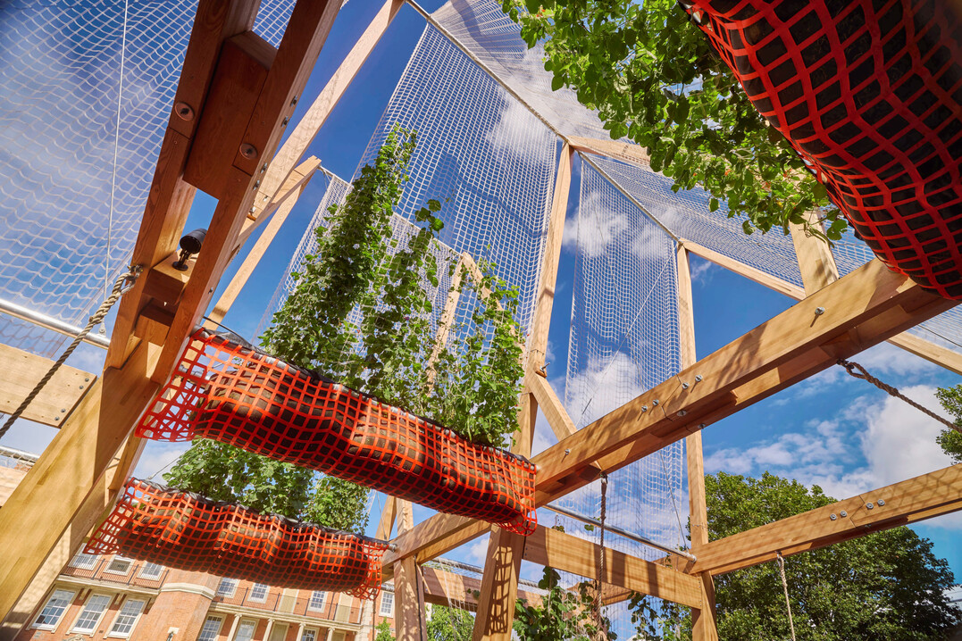 In Zusammenarbeit mit dem American Hardwood Export Council entstand f�r das London Design Festival 2024 das publikumswirksame Vert | Triangel mit schwingenden Sitzb�nken unter Laubd�chern.