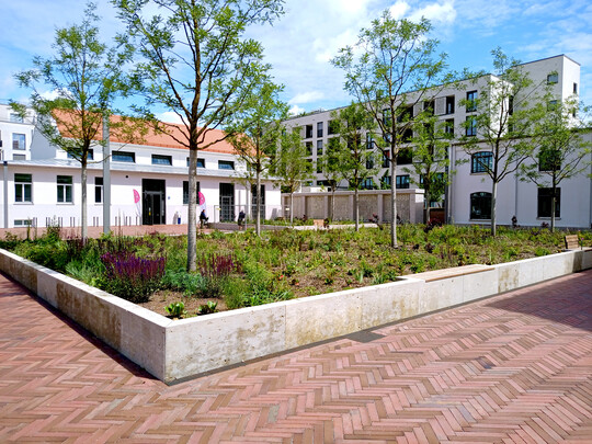 Der Quartiersplatz im Diamaltpark bildet zugleich die Mitte und den Begegnungsort im neu geschaffenen Quartier.