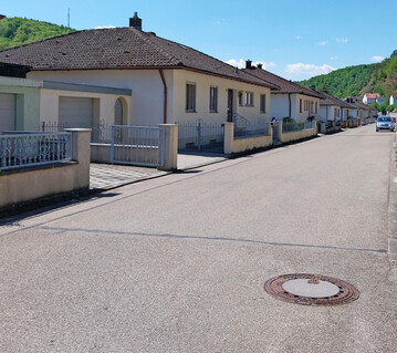 Siedlungsstrae ohne Grn, bei der sogar die Privatgrundstcke versiegelt sind. Hier sprt man frmlich die glhende Hitze im Sommer.
