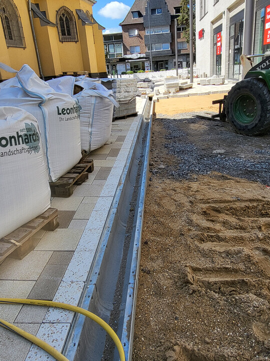 Der Einbau der BIRCOsir-Rinne. Sie wird gesetzt wie eine normale Entwässerungsrinne mit Fundament und Rückenstütze.