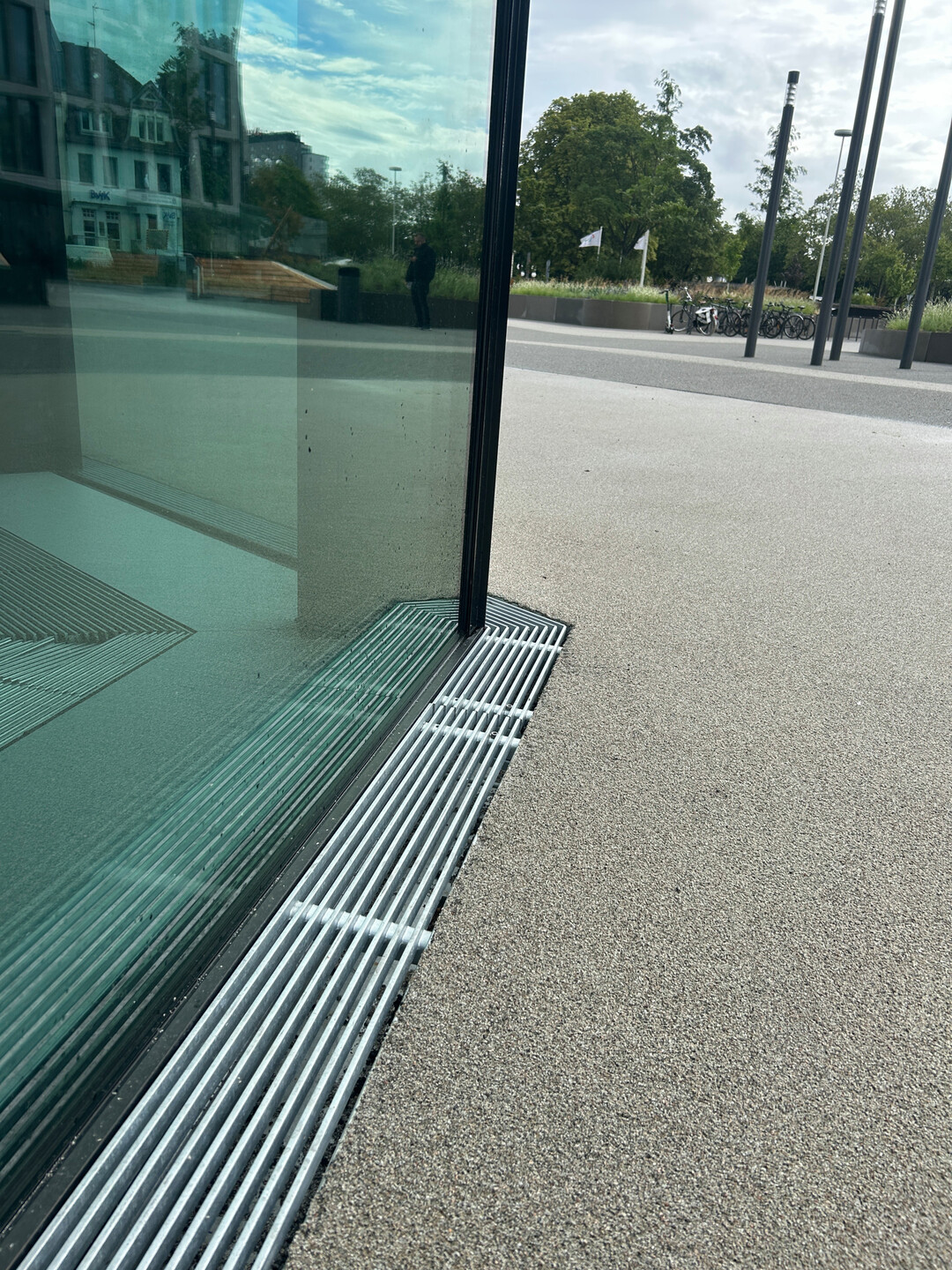 Die ACO Fassadenrinnen mit Längsstabrosten werden individuell auf die sechseckige Gebäudegeometrie angepasst.