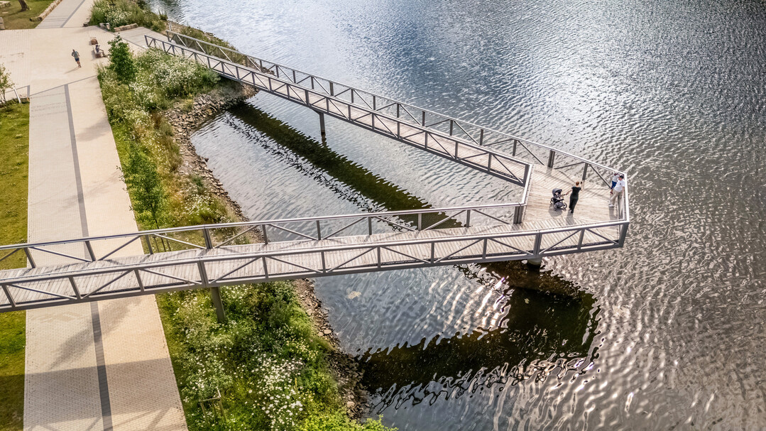 Über dem Südufer schwebt ein imposanter Steg, der in seiner Architektur an Zeiten der Industrie erinnert.