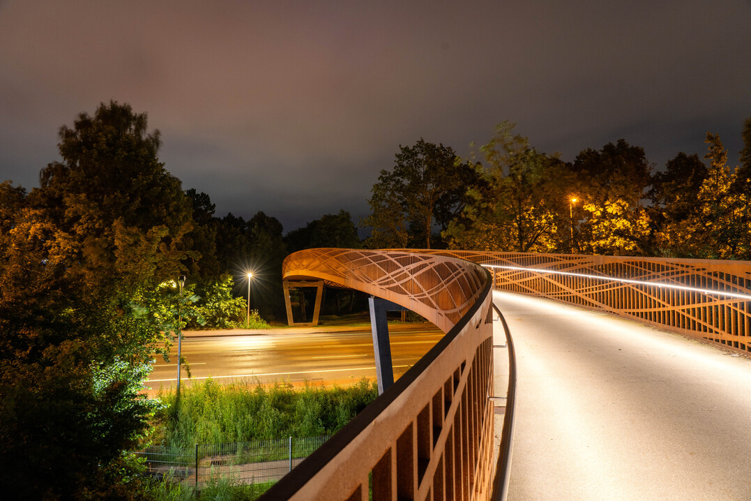 Dynamische Bänder aus Licht und Cortenstahl machen die Dalkebrücke in Gütersloh auch nachts zum Ereignis.
