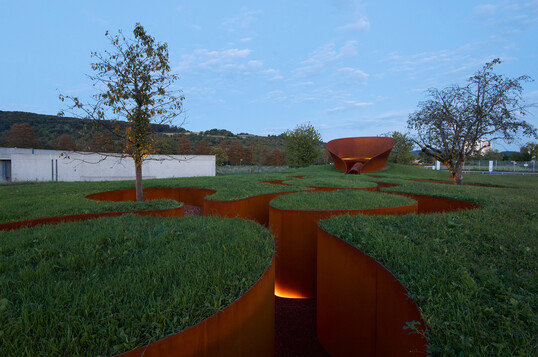 Tagsüber fügt sich das Refugium ruhig in die Landschaft ein, nachts offenbart es sich durch einen sanften Schein.