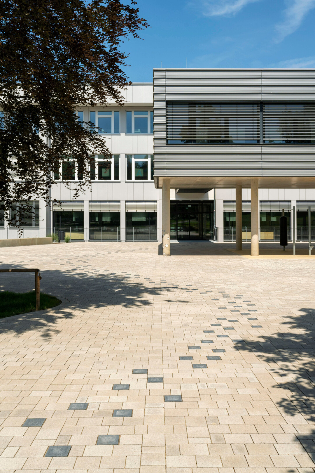 Der neugestaltete Schulhof hat nun ein versickerungsf�higes Pflaster, mehr Gr�n- und Pflanzfl�chen sowie B�ume f�r mehr Schatten.