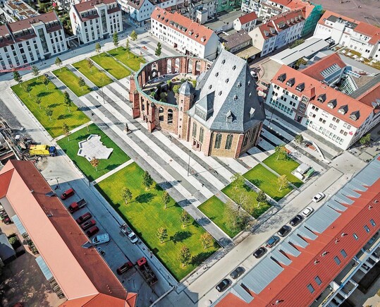 Die plakative Platzgestaltung schafft einen starken Konterpart zur markanten Kirche in der Mitte.