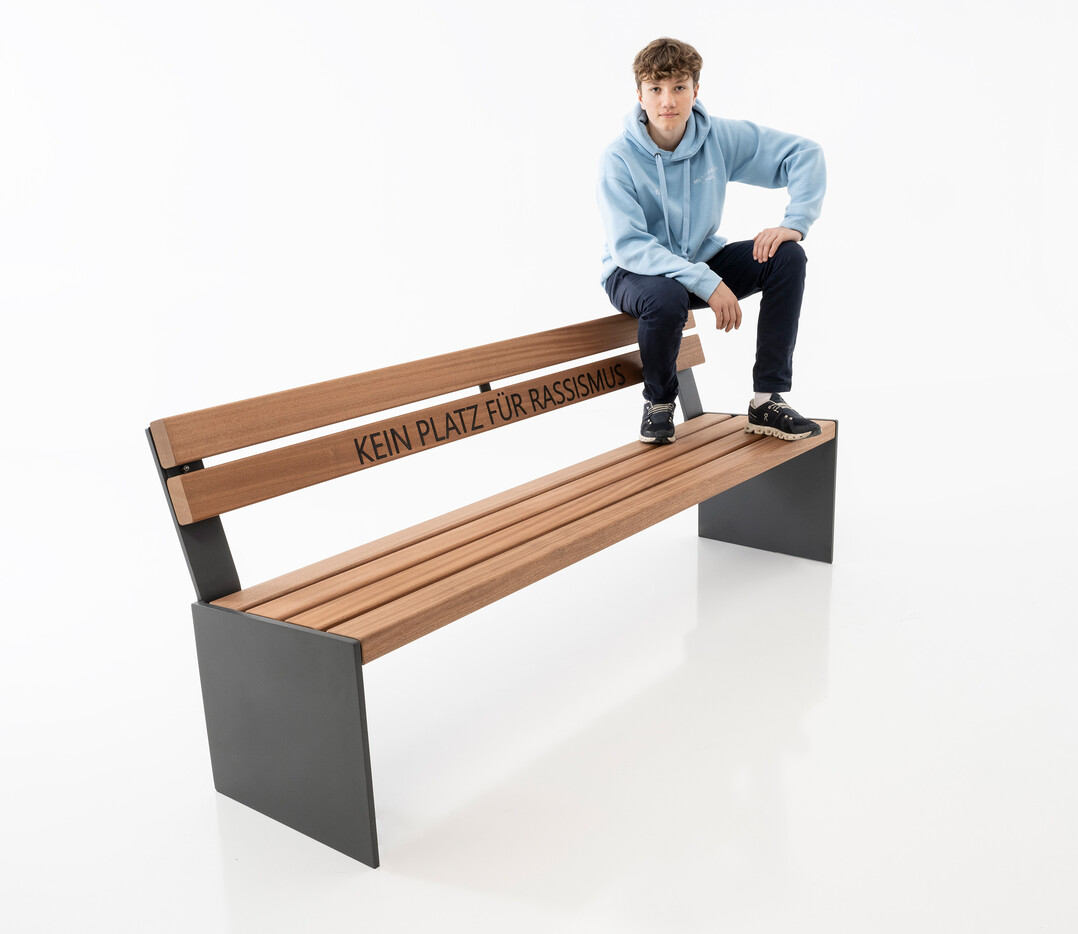 Die Bank BINGA von Runge, hier mit der in die Holzrückenlehne eingelaserten Aussage „Kein Platz für Rassismus“