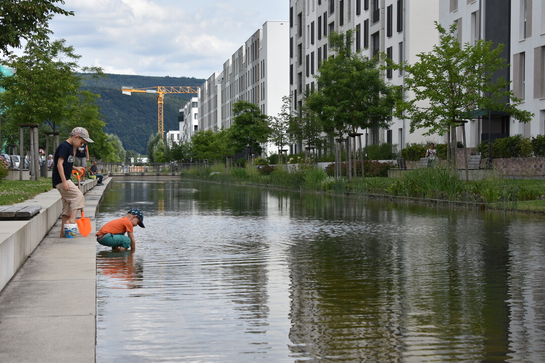 Wasserflächen im Wohnquartier machen das Mikroklima angenehmer, helfen beim Regenwassermanagement, sind optisch reizvoll und üben eine magische Anziehungskraft auf Kinder aus.
