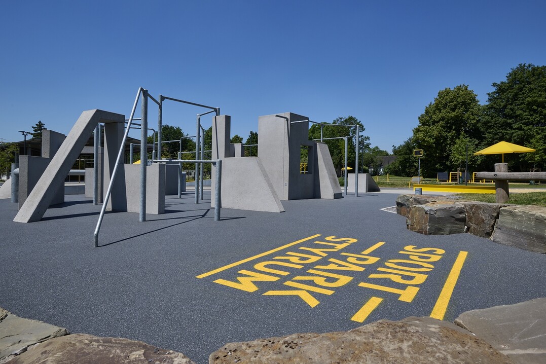 Im Bereich der Calisthenicsanlage kam der Allroundbelag PolyPlay S zum Einsatz. Darin eingelassen ist der Name des Sportparks.
