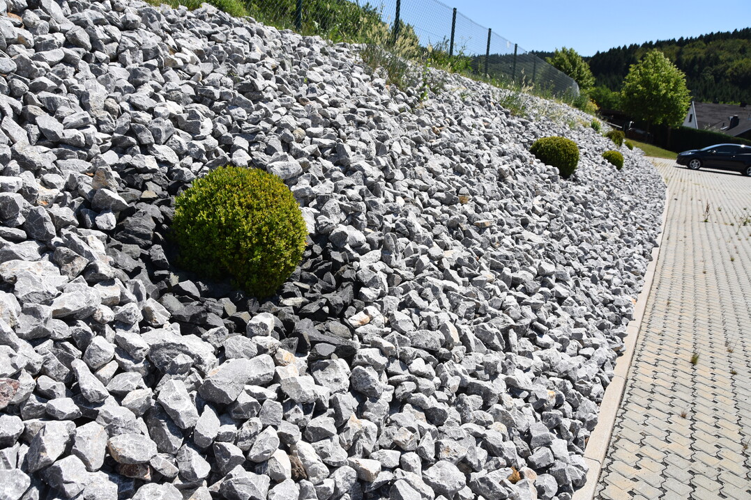 Auch wenn diese Schttung aus grobem Basalt- und Granitschotter Gestaltungswillen erkennen lsst: Es ist weder pflegeleicht noch attraktiv. Eine magere Wiesenbschung wre attraktiver und kologisch deutlich wertvoller gewesen.